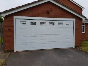 Electric-sectional-garage-door-in-white-with-sunrise-windows